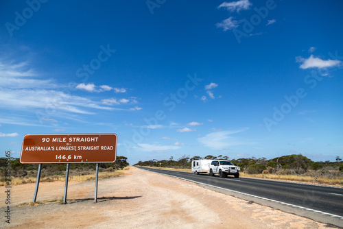 White 4WD towing a caravan along the 90 Mile Straight on the Eyre Highway on the Nullarbor photo