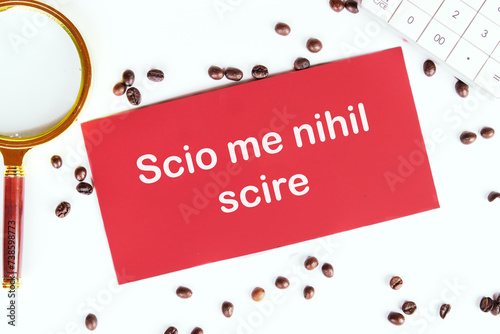 Scio me nihil scire It is translated from Latin as I know I don't know anything. It's written on the red card photo
