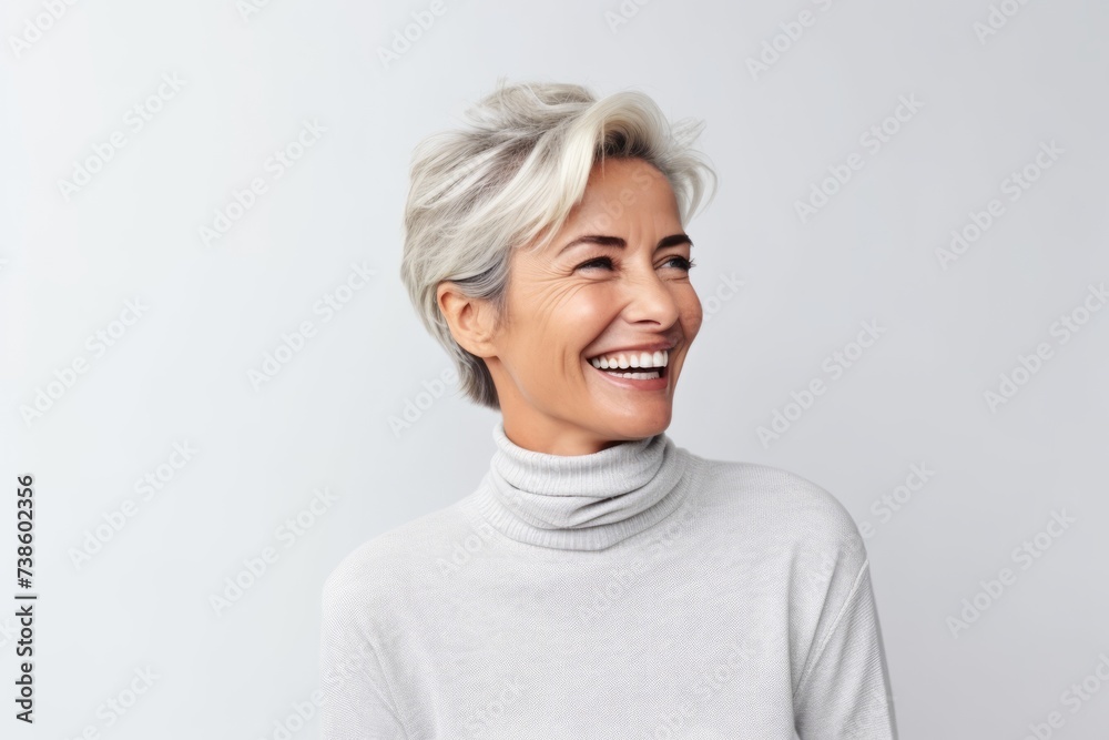 Happy middle aged woman with short grey hair laughing and looking at camera Happy middle aged woman with short grey hair laughing and looking at camera