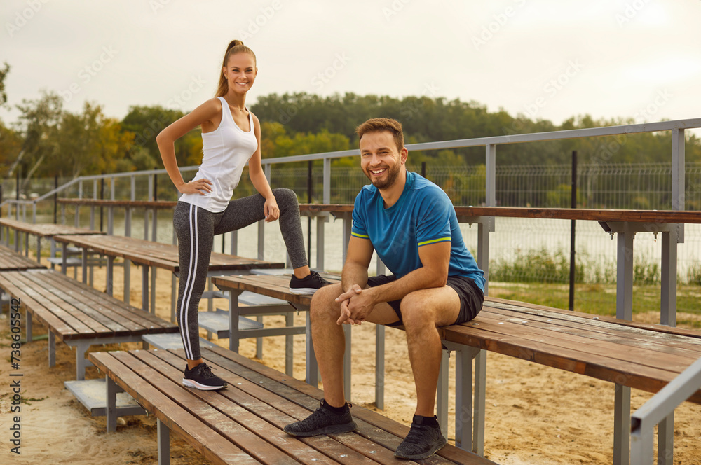 Radiant sport couple embraces an active lifestyle during a workout session in the park. Against the backdrop of a vibrant city park, man and woman engages in fitness activities on a sports ground.