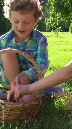 Two children boy and girl having easter egg hunt in garden backyard