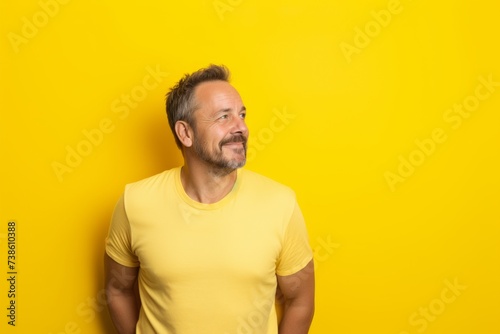 Portrait of a bearded man in a yellow T-shirt on a yellow background © Loli