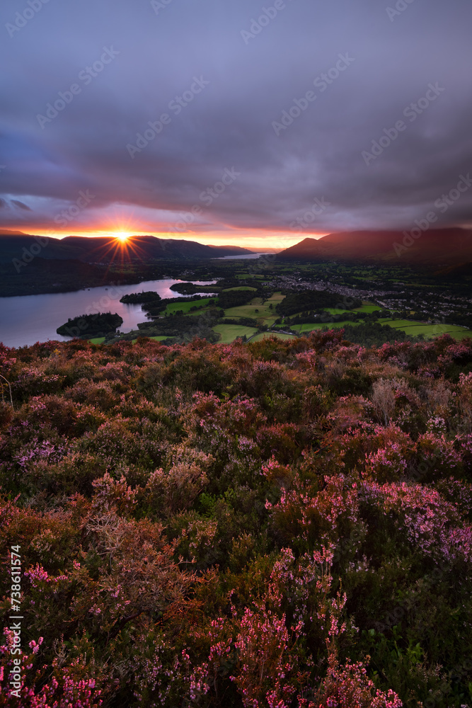 Dramatic sunset overlooking Derwentwater and Keswick seen from a heather filled Walla Crag in The Lake District, UK.