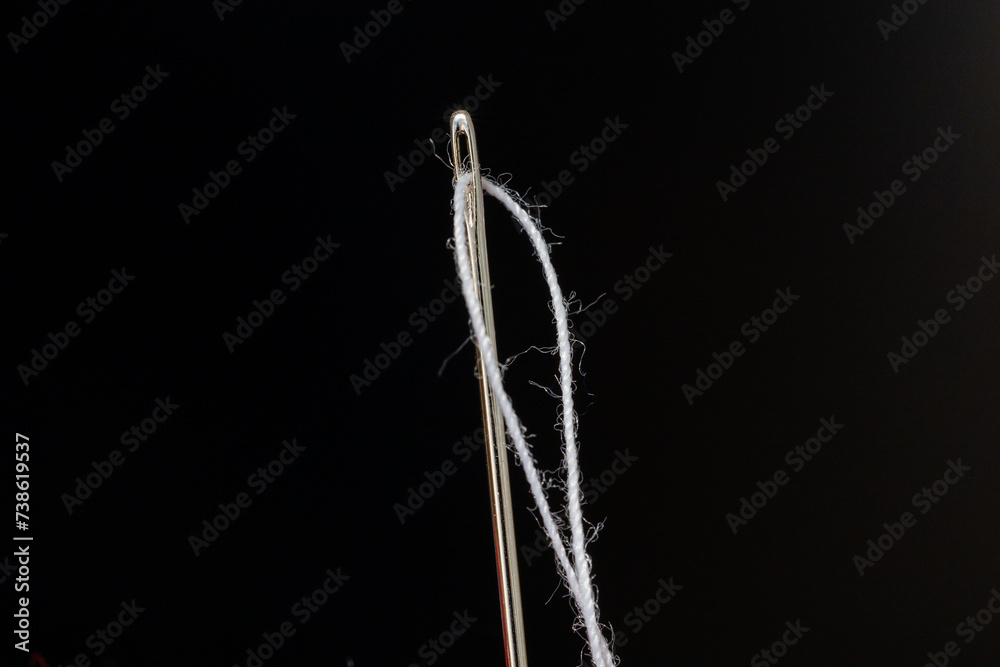 thread threaded into a sewing needle
