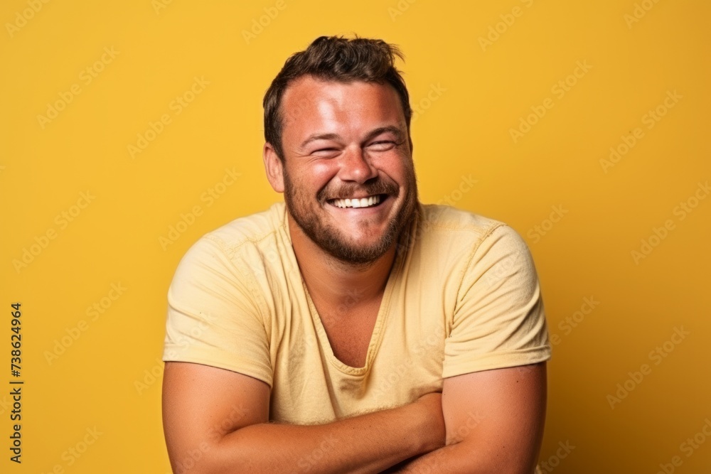 Portrait of a happy young man laughing on yellow studio background. Portrait of a happy young man laughing on yellow studio background.