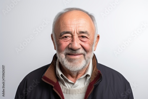 Portrait of a senior man with grey hair and beard on a white background