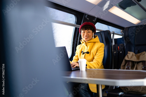 Obraz na plátně Beautiful woman traveling by train, working on laptop computer and enjoying the journey