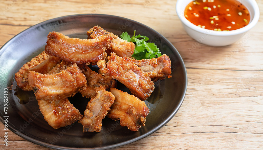 Deep Fried Crispy Pork Belly Cooked with Garlic and spicy dipping sauce on wooden table background