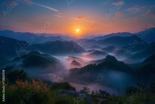 Sunrise over a misty valley, with layers of hills visible in the distance, nature landscape © arhendrix