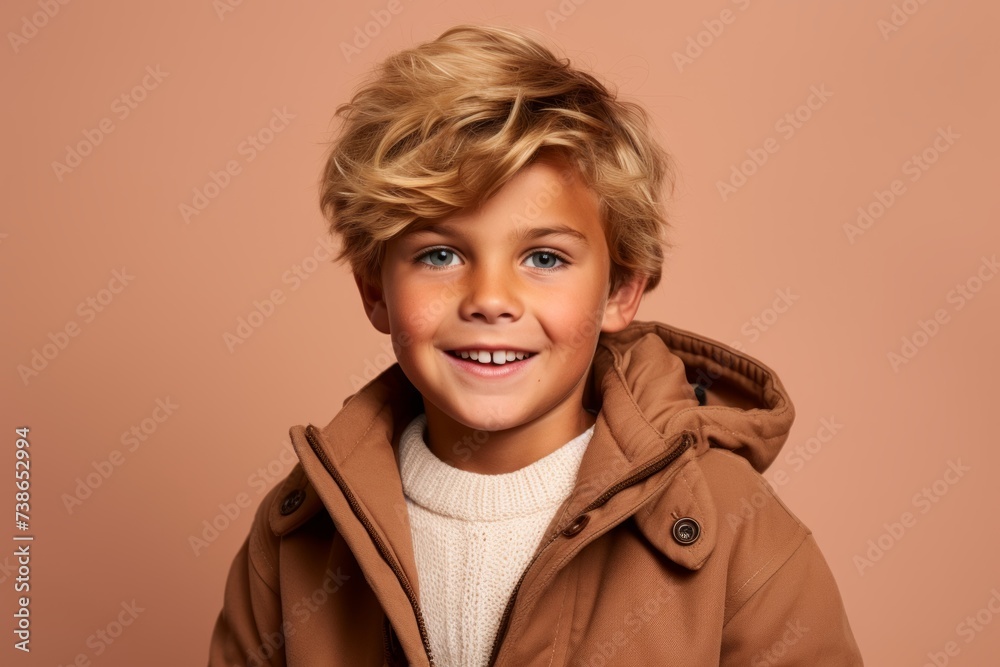 Portrait of a smiling little boy with blond hair in a brown coat. Portrait of a smiling little boy with blond hair in a brown coat.
