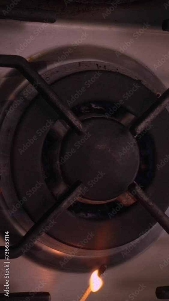 Vertical video social media format – Slow motion closeup overhead shot of a match lighting a gas cooker hob burner. Vertical video social media format – Slow motion closeup overhead shot of a match lighting a gas cooker hob burner.