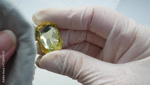 gemologist or gemstones dealer evaluating a big yellow pure gemstone. Pawnshop concept