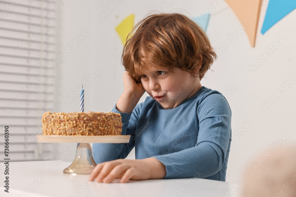 Cute boy with birthday cake at white table indoors Cute boy with birthday cake at white table indoors