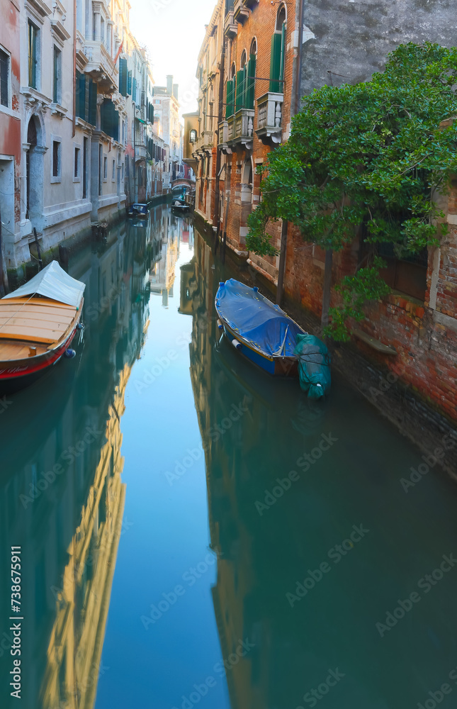 glimpse of a navigable canal on the island of Venice with boats