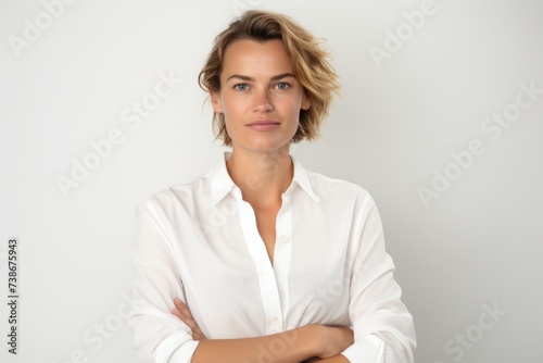 Portrait of a beautiful business woman in a white shirt on a gray background