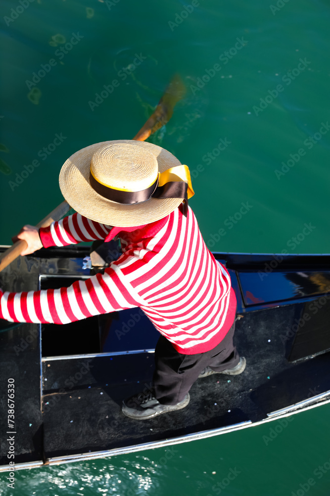 Venetian gondolier with hat rowing on gondola boat on the water of grand canal in Venice Italy - obrazy, fototapety, plakaty 