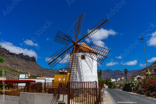 An old Wind Mill and some oversized pots cans coffee grinders in Mogan on Gran Canaria Island Spain. 
