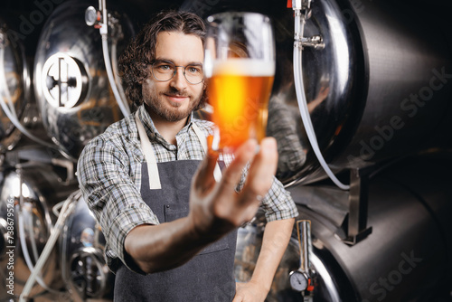 Brewer man working on alcohol manufacturing production. Brewery factory owner inspector checking control quality of craft beer photo