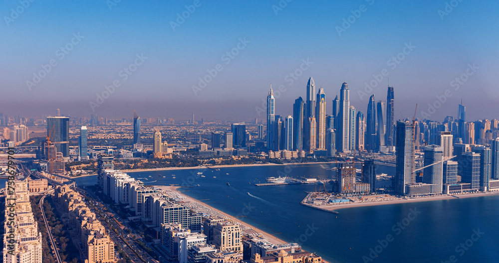 Fototapeta premium Aerial top view skyscraper of Dubai Marina sand beaches in Persian gulf, sunset. Banner UAE tourism from drone.
