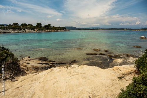 Panoramic view of Karidi beach. Vourvourou, Sithonia, Greece, Halkidiki. Wild beautiful beach with turquoise water. Mediterranean panorama landscape of Karidi sandy beach with pine tree  on coast. photo