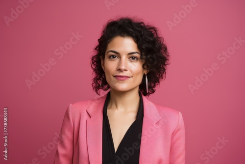 Portrait of a beautiful woman with curly hair on a pink background