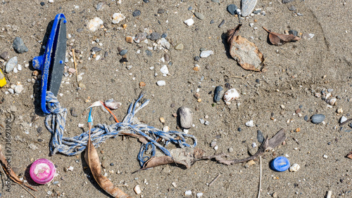 Obraz na plátně Top down view of assorted plastic rubbish and junk washed ashore onto sandy beac