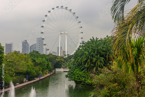A landscape view from Gardens by the Bay and Singapore observation wheel in the background. Gardens By The Bay the most popular tourist attraction in Singapore city