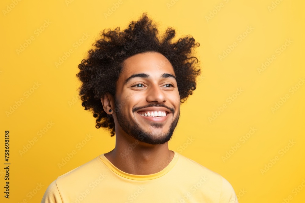 Portrait of smiling afro american man with curly hair on yellow background Portrait of smiling afro american man with curly hair on yellow background