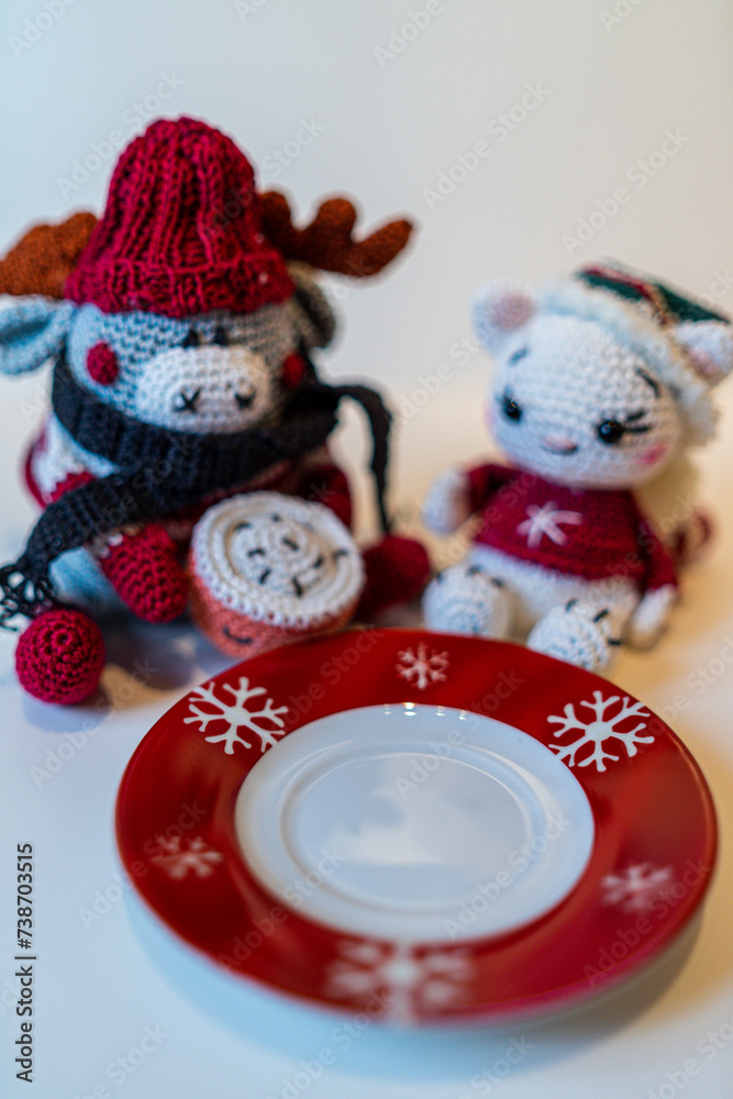 Fototapeta premium Various homemade cookies from the Christmas bakery on a small plate. And a moose and a cat amigurumi figures with Christmas clothes.