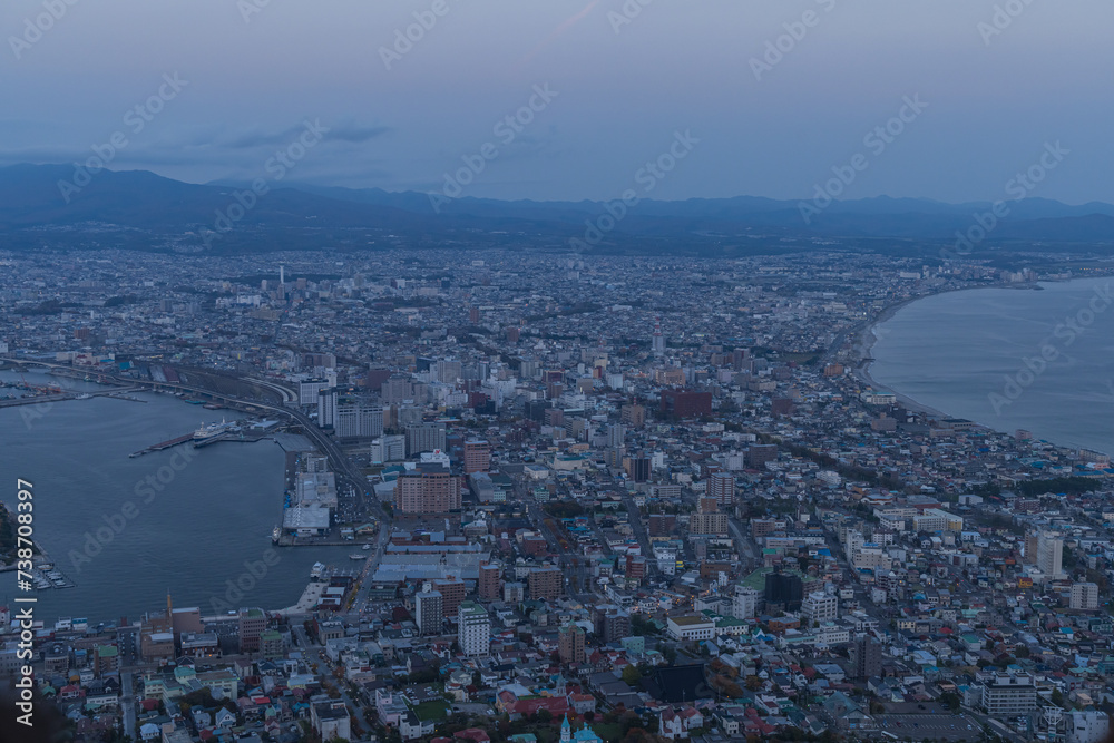 Fototapeta premium 日本 北海道函館市にある函館山展望台から見える夕暮れ時の市街地の街並みと津軽海峡