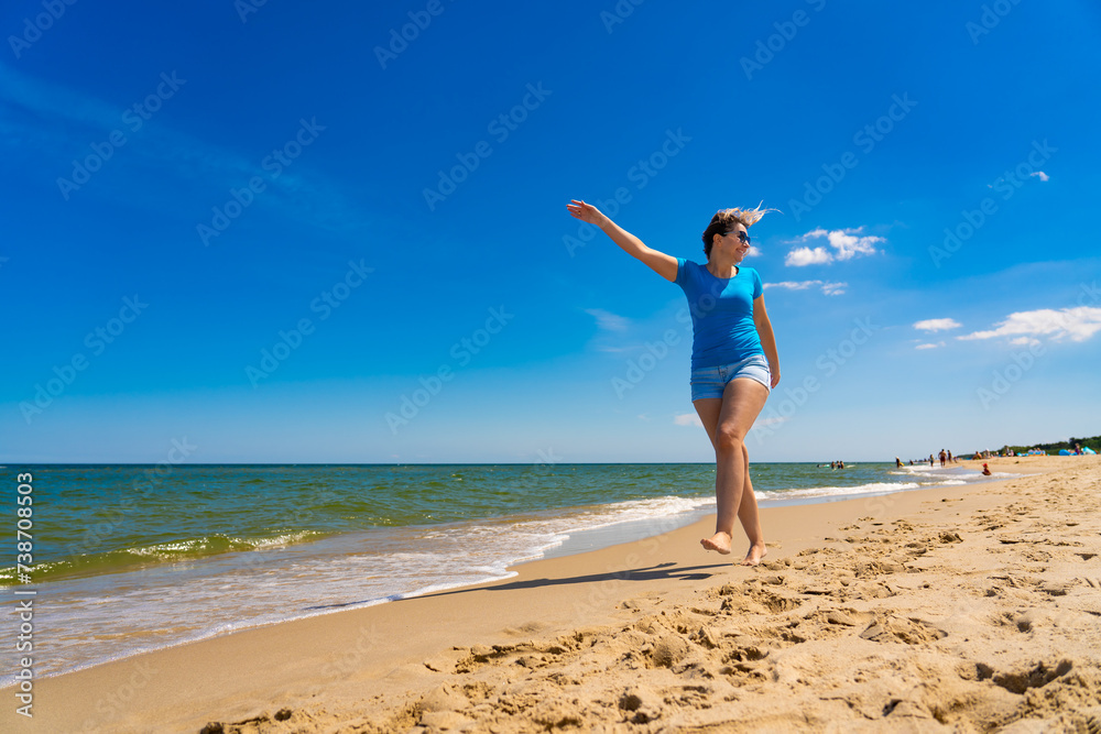 Beautiful mid adult woman walking on sunny beach
Beautiful mid adult woman walking on sunny beach
