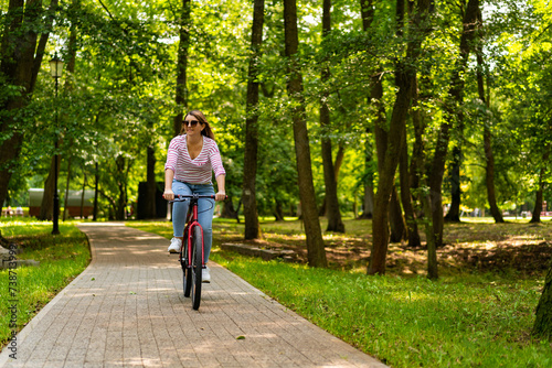Wallpaper Mural Beautiful mid adult woman riding bicycle in city park
 Torontodigital.ca