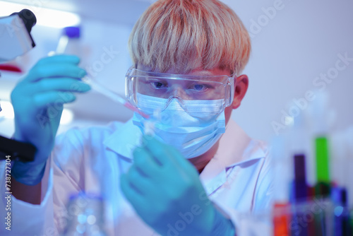 Asian middle-aged male scientist conducts research in a laboratory, surrounded by petri dishes and beakers. Investigate the chemistry of gasoline, food ingredients, perfumes, viruses, and medicine