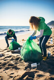 Volunteers collecting garbage on the beach. Selective focus.
