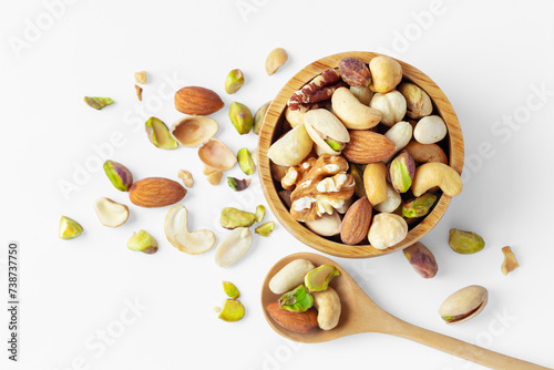 Mixed nuts in wood bowl with spoon on white background photo