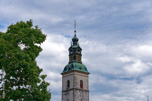 Scenic view of church tower at Slovenian City of Skofja Loka on a cloudy summer day. Photo taken August 9th, 2023, Škofja Loka, Slovenia.