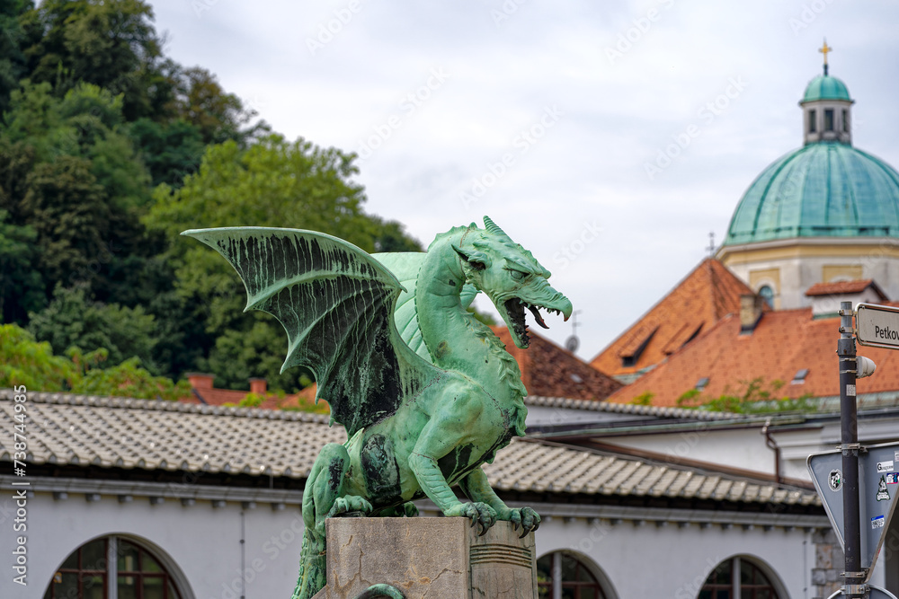 Close-up of green bronze dragon sculpture at famous Dragon Bridge City of Ljubljana on a cloudy summer day . Photo taken August 9th, 2023, Ljubljana, Slovenia.