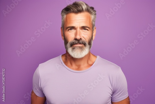 Portrait of handsome mature man with grey beard and mustache. Isolated on purple background.