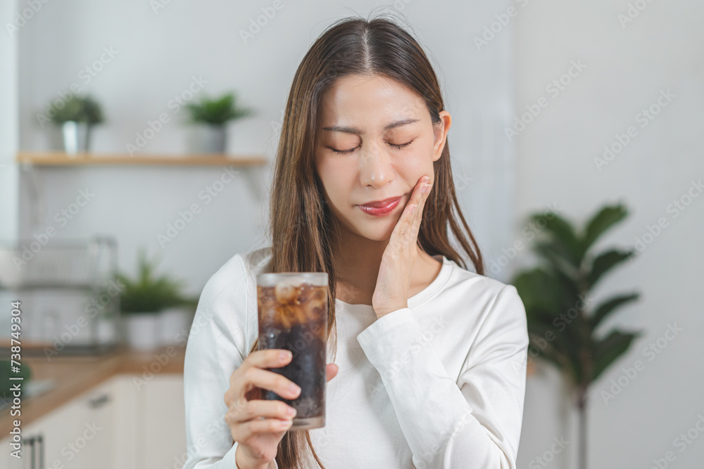 Health asian young woman touching her mouth, expression, suffering from toothache, decay or sensitivity cavity molar tooth or inflammation drink cold, sparkling water at home.Sensitive teeth people. Health asian young woman touching her mouth, expression, suffering from toothache, decay or sensitivity cavity molar tooth or inflammation drink cold, sparkling water at home.Sensitive teeth people.