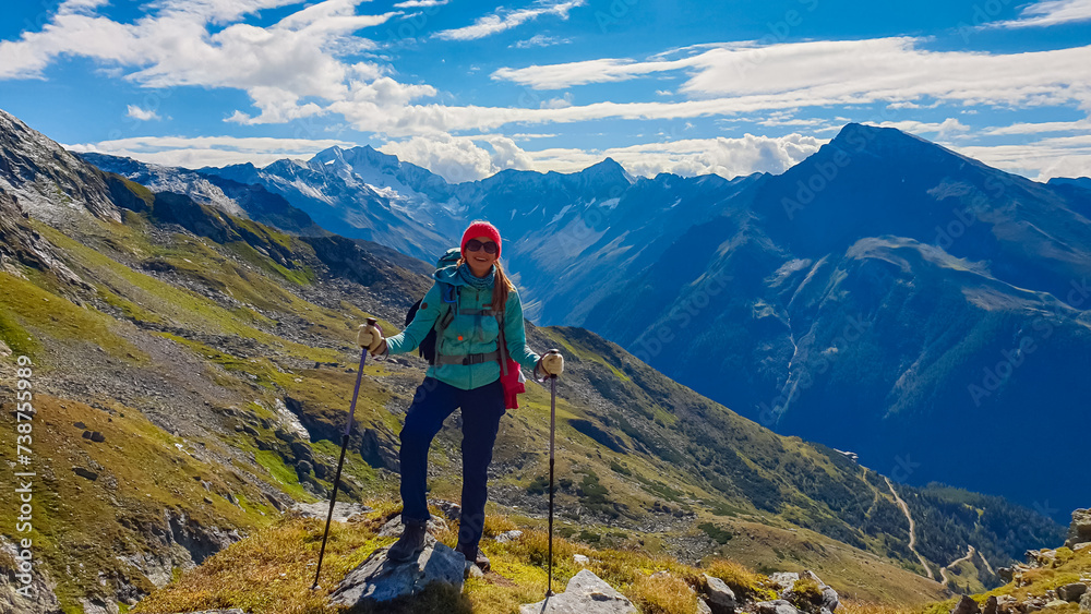 Hiker woman on alpine meadow with panoramic view of majestic mount Hochalmspitze in High Tauern National Park, Carinthia, Austria. Idyllic hiking trail in Austrian Alps. Wanderlust paradise Mallnitz