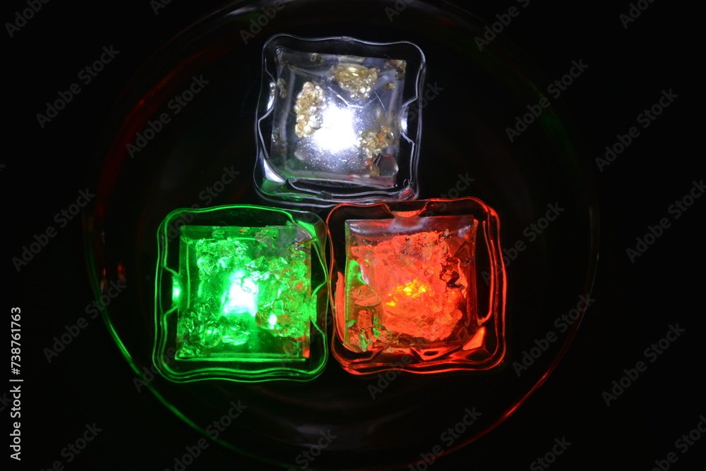 Beautiful, stylish photo of parties, celebrations, one glass champagne glass with glowing plastic ice cubes in drinks that glow with green, red and white light. Beautiful, stylish photo of parties, celebrations, one glass champagne glass with glowing plastic ice cubes in drinks that glow with green, red and white light.
