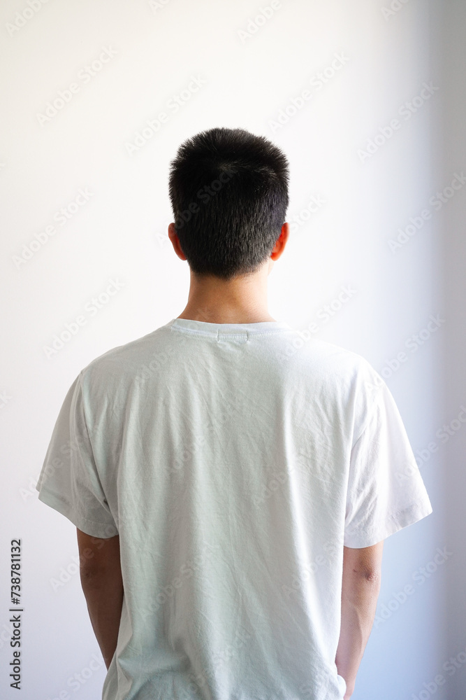 白いTシャツを着た若い男性の後ろ姿 白背景 白いTシャツを着た若い男性の後ろ姿 白背景