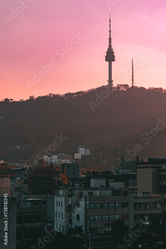 Tour de Seoul au coucher de soleil avec des batiments en premier plan