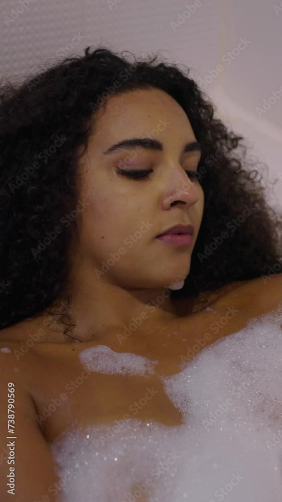 Attractive brunette woman rubbing her body with bath foam Attractive brunette woman rubbing her body with bath foam