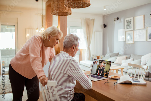 Senior couple talking to doctor on video call from home photo
