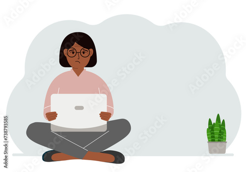 A woman sits cross-legged in his hands holding a laptop. The concept of work, education, reading, watching videos.