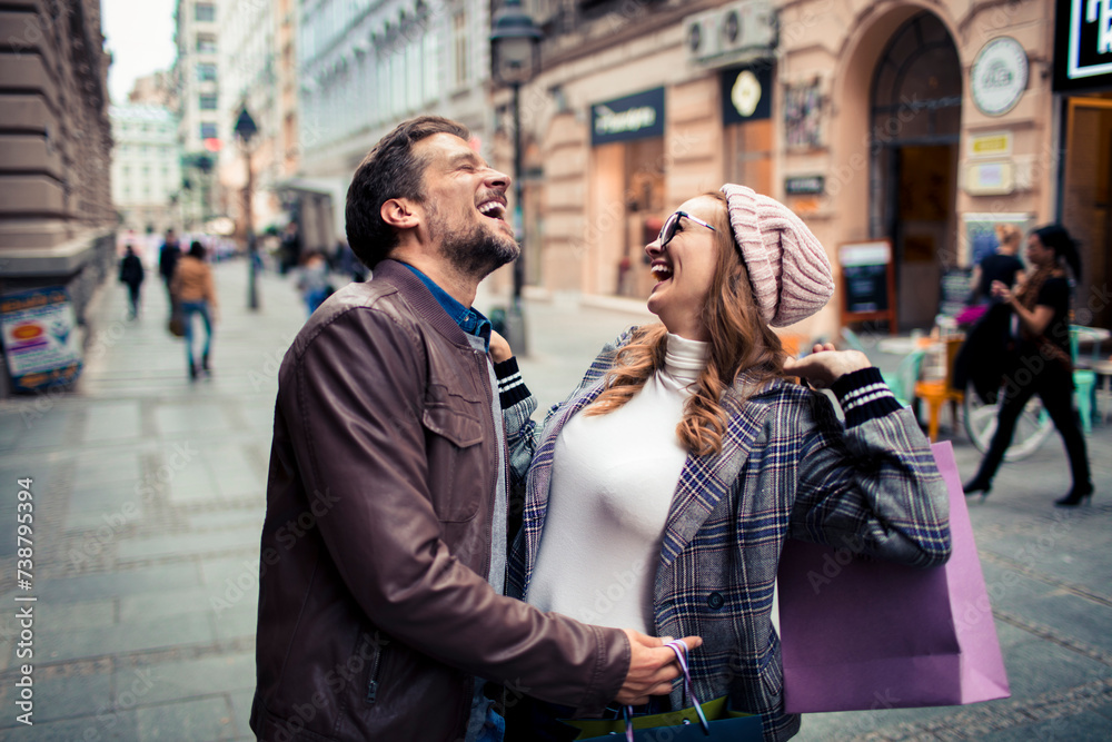 Happy young couple looking for stores downtown