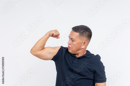 A middle aged man proudly showing his bulging bicep, very fit in his fifties. Isolated on a white background.