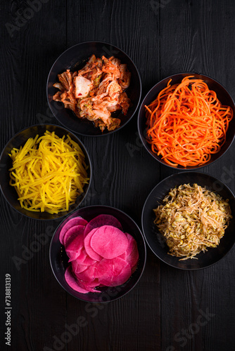 Korean food. five salads on a black wooden background