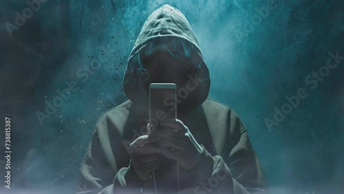 A symbol of cybersecurity threats, a hooded figure represents the elusive nature of computer hackers photo